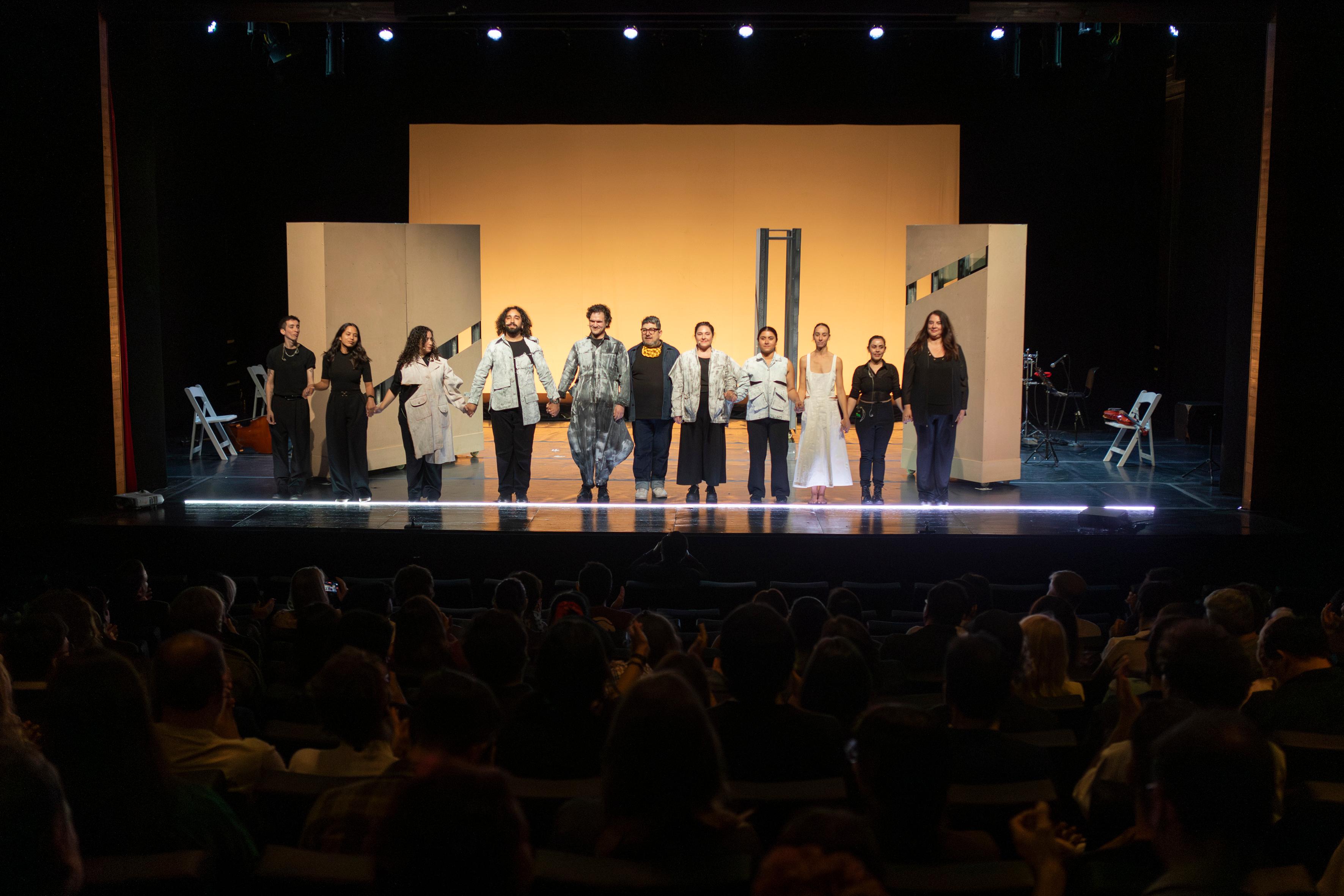 Full cast taking a bow in front of an audience.